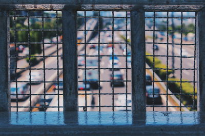 Close-up of metal railing against window