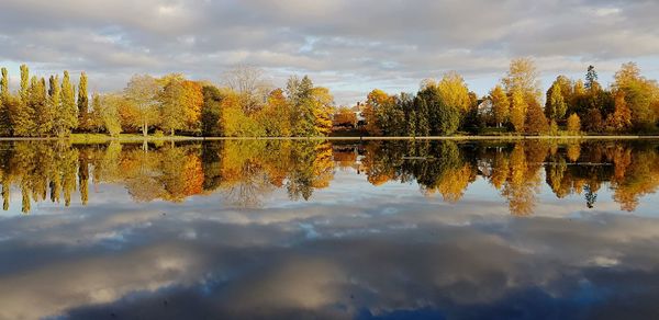 Reflection of trees in lake against sky during autumn