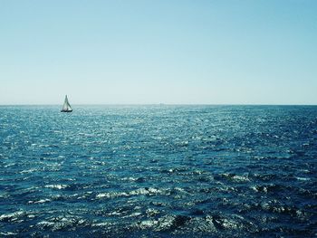 Sailboat sailing in sea against clear sky