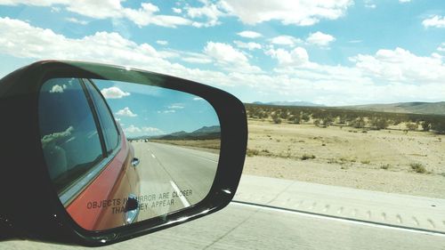 Reflection of landscape on side-view mirror