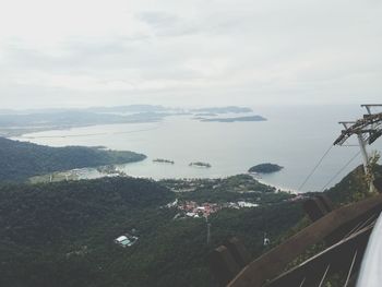 Aerial view of city by sea against sky