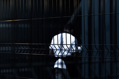 Person seen through metal grate