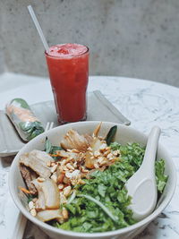  fresh spring rolls with vegetable,pork and shrimps. salad bowl with pork,carrot. water melon juice