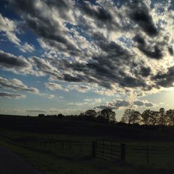 Scenic view of grassy field against cloudy sky