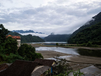 Scenic view of lake by mountains against sky