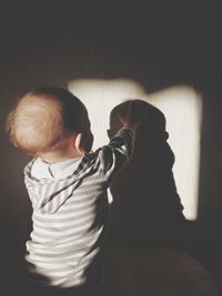 Side view of boy looking through window