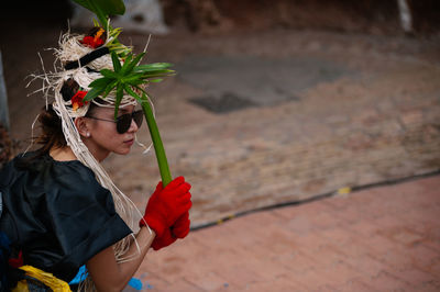 Midsection of woman holding red flowering plant