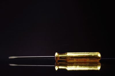 Close-up of screwdriver against black background