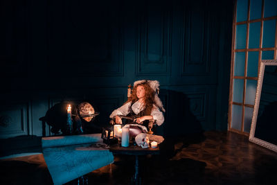 Young woman sitting on table at home