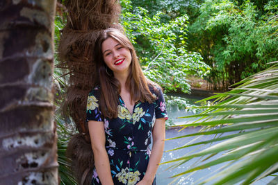 Portrait of smiling young woman against plants