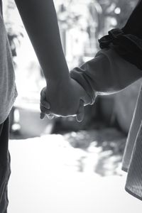Midsection of couple holding hands