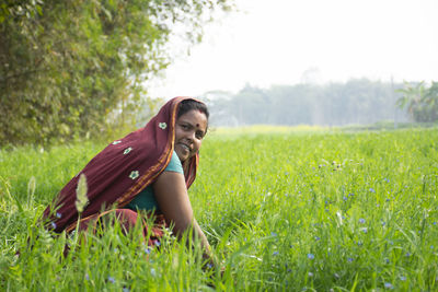 Woman wearing sari working on field in rural india