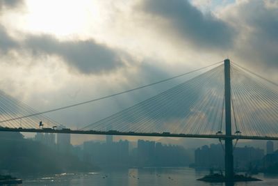 View of suspension bridge against cloudy sky