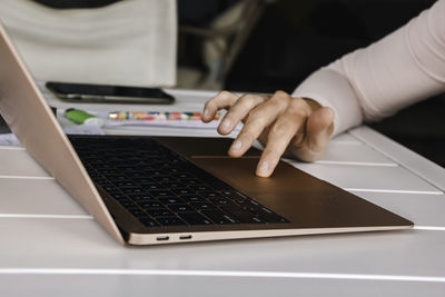 Midsection of woman using laptop on table