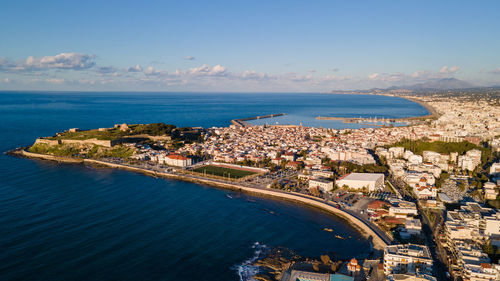 High angle view of townscape by sea against sky