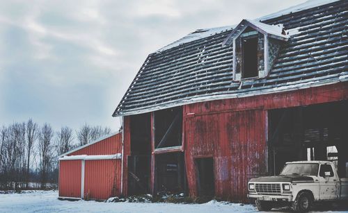 Abandoned barn against sky during winter
