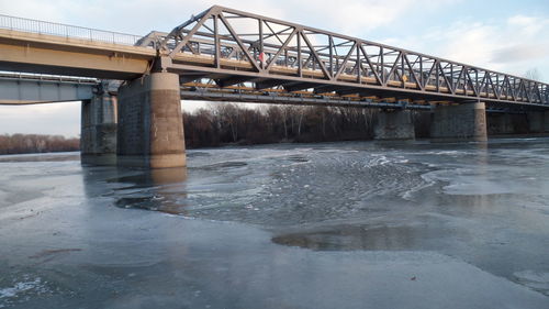 Low angle view of bridge over river against sky