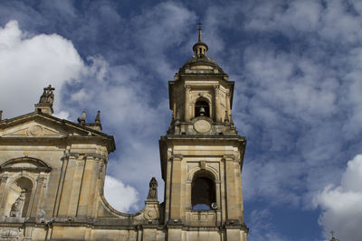 Low angle view of bell tower against cloudy sky