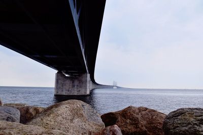 Low angle view of oeresund bridge on sea against sky