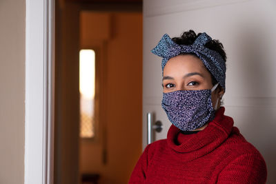 Portrait of sérios african american womanwith matching headband and face mask looking at camera.