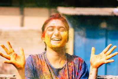 Close-up portrait of happy woman covered with powder paint