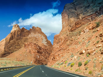 Road leading towards mountains against sky