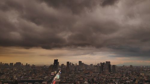 Aerial view of city buildings against storm clouds