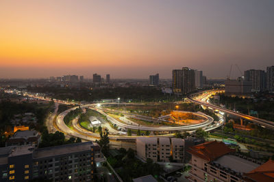 High angle view of illuminated cityscape at sunset