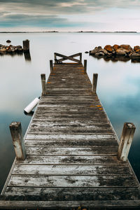 Wooden pier over sea against sky