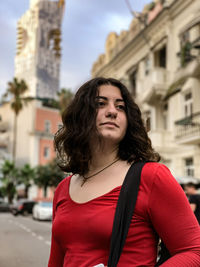 Beautiful woman looking away while standing in city