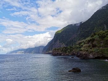 Scenic view of sea and mountains against sky