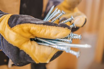 Cropped hand of carpenter holding screw in hand