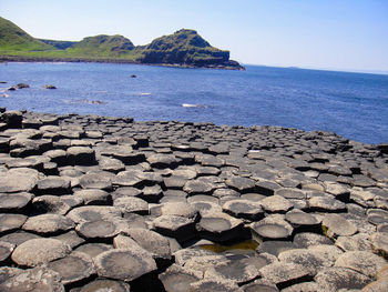 Scenic view of rocks on beach against clear sky