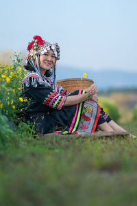 Woman with umbrella sitting on land