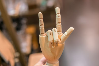 Close-up of wooden hand with horn gesture