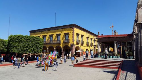 Group of people in building against clear sky