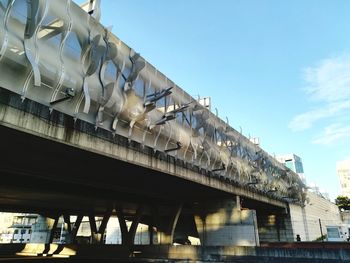 Low angle view of bridge over building against sky