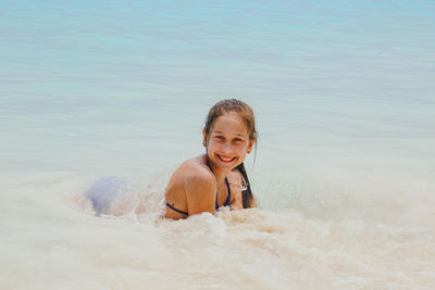 Portrait of smiling boy swimming in sea