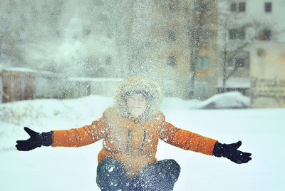 Man with arms raised standing in snow