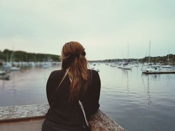 Rear view of woman overlooking calm lake