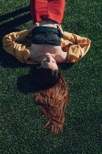 High angle view of woman sleeping on grass