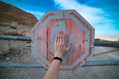 Cropped hand of woman standing on wall