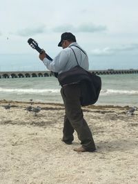 Full length of man standing on beach against sky