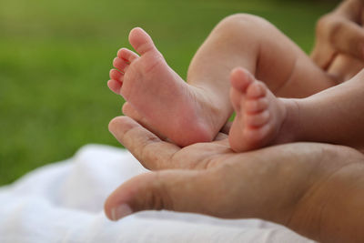 Close-up of baby feets on a mothers hand