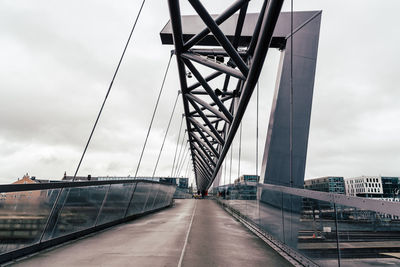 View of suspension bridge against cloudy sky