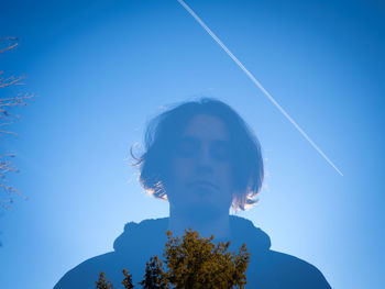 Low angle view of man against blue sky