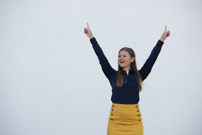 Smiling young woman standing against white background