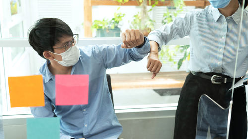Colleagues doing elbow bump in office