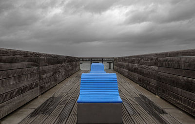 Empty pier over sea against sky