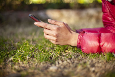 Midsection of man using mobile phone in field
